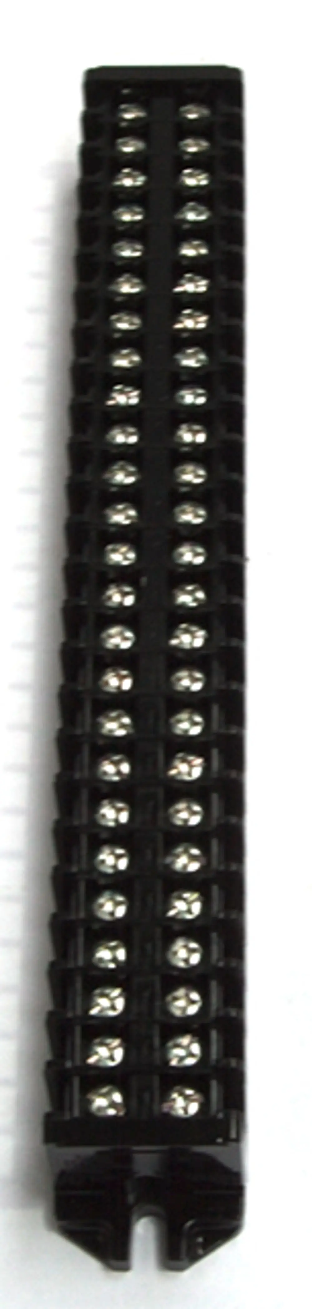 Schmale, schwarze Klemmleiste von Daikin mit mehreren metallenen Anschlussklemmen in einer vertikalen Anordnung auf einem weißen Hintergrund.
